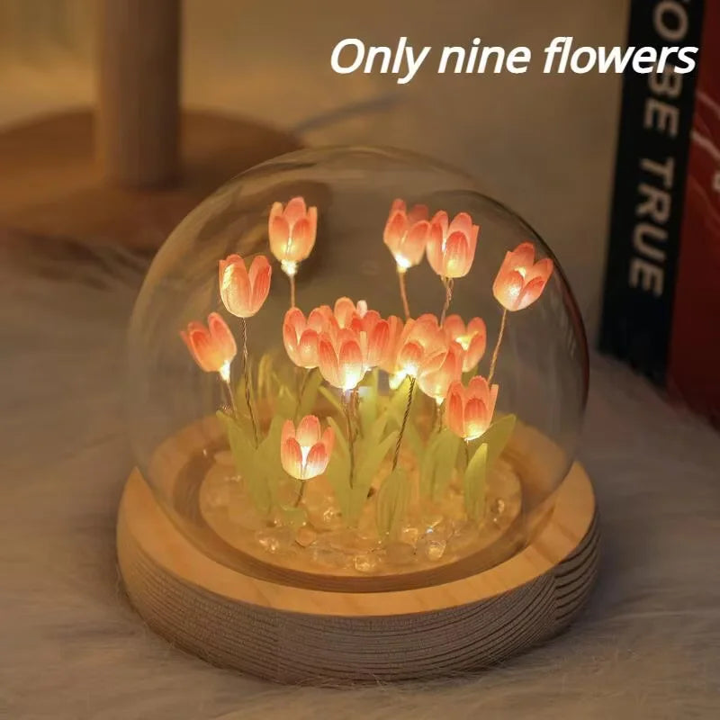 A glass cloche containing nine glowing orange tulips used as a handmade LED night light.