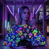 A woman holds a folding rave hand fan with a vibrant, fluorescent UV glow pattern featuring colorful mushrooms and butterflie