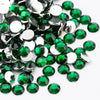 A close-up view of round flatback resin rhinestones in various shades of green and silver.