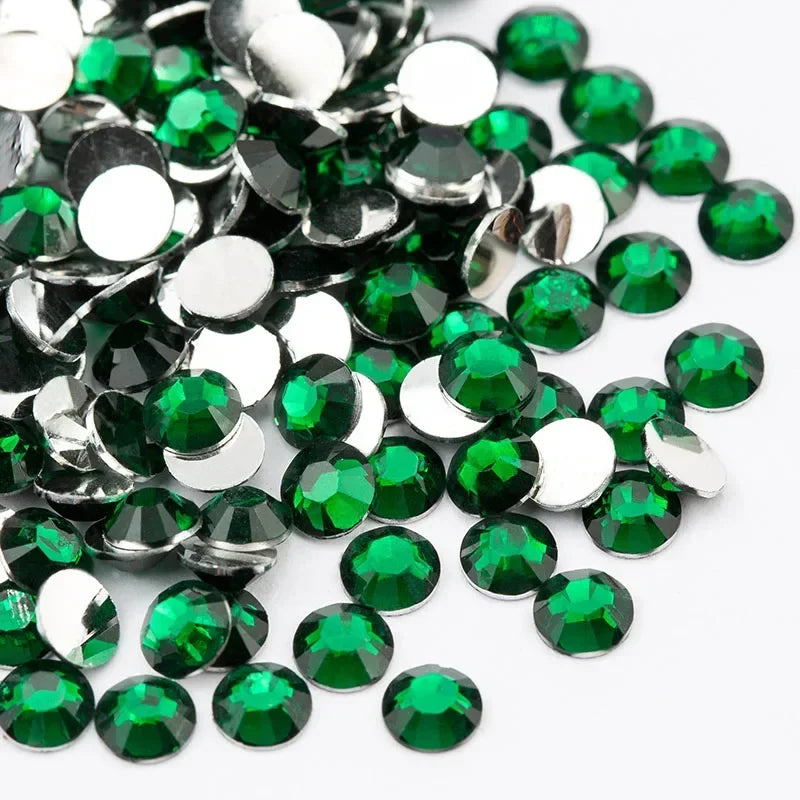 A close-up view of round flatback resin rhinestones in various shades of green and silver.