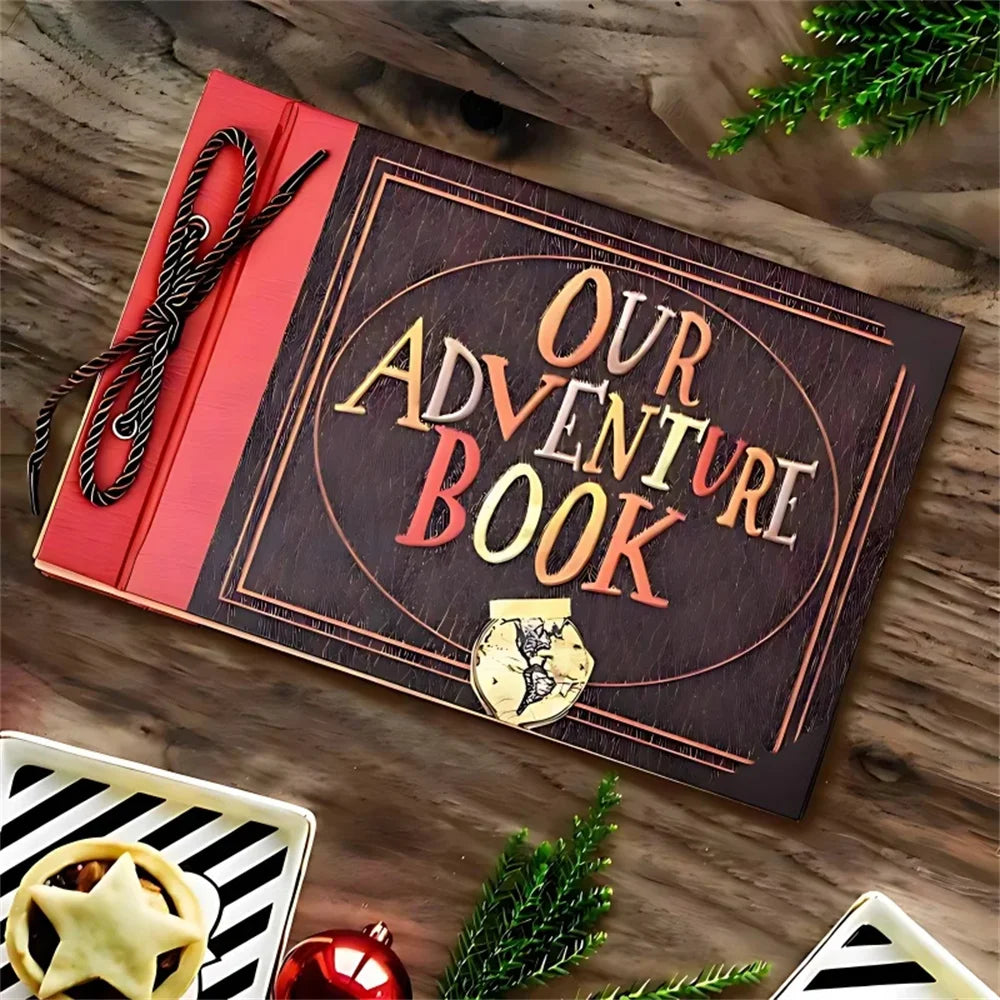 A vintage kraft scrapbook album titled Our Adventure Book resting on a wooden surface with greenery and a star-shaped item.