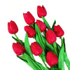 A bouquet of six vibrant red artificial tulips with green stems and leaves.