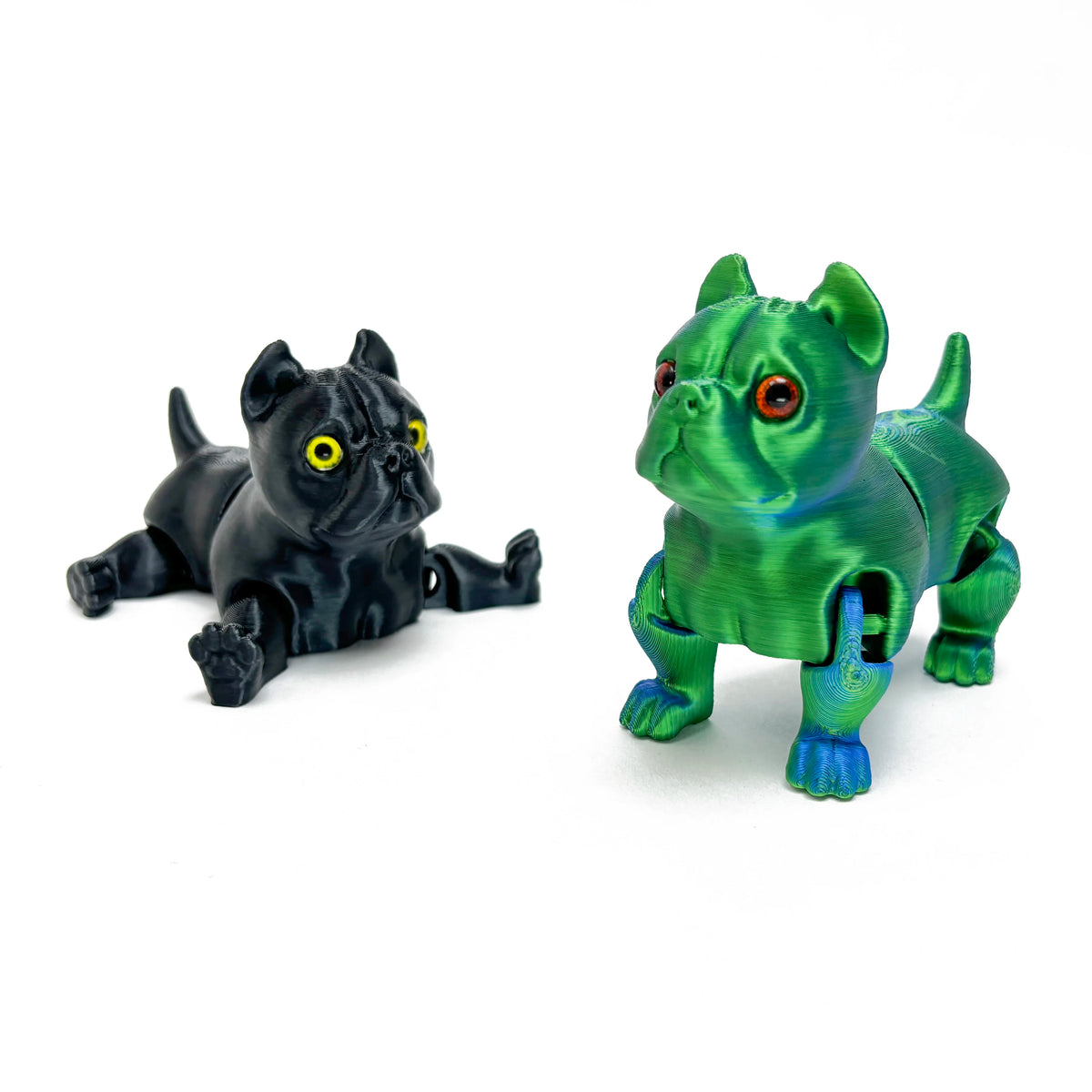 A pair of 3D printed articulated bulldog figurines, one black and one green.
