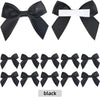 A set of black satin ribbon bows with white adhesive backing for crafting and gift wrapping