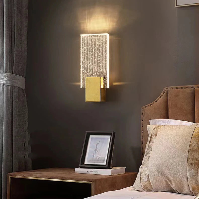 Modern bubble crystal LED wall sconces mounted above a wooden nightstand in a dimly lit bedroom.
