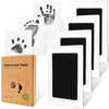 A set of four white cards featuring black ink hand and foot prints, packaged in a brown box.