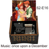 A hand-cranked wooden music box featuring an illustration of two characters, labeled 62-E16.