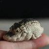 A small, textured resin crocodile tea pet ornament held in a person's hand.