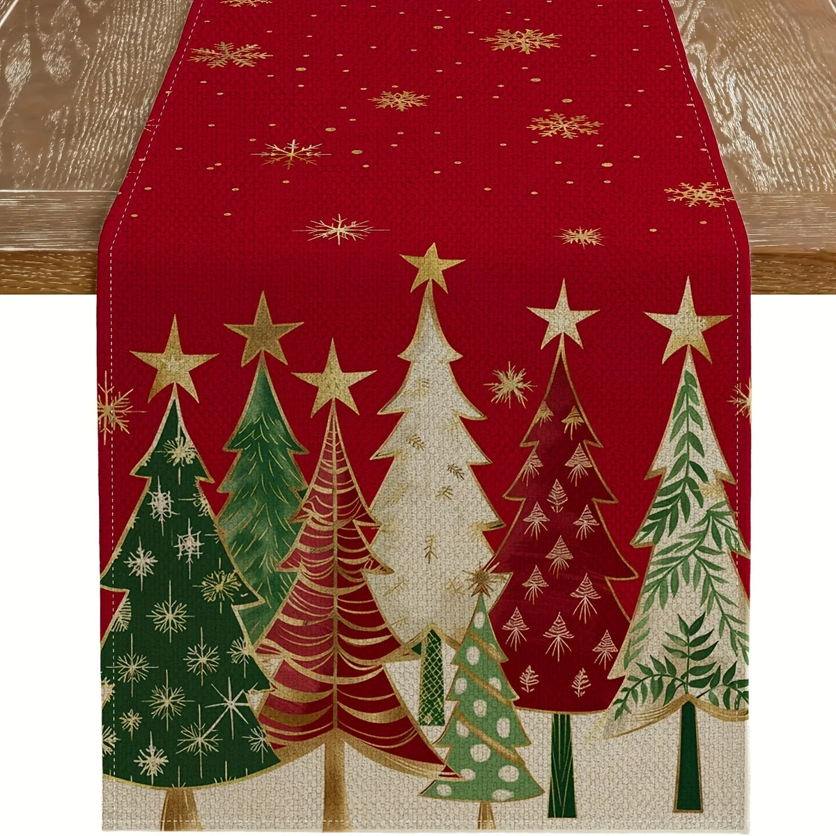 Un camino de mesa navideño festivo con un patrón de árboles de pino verdes y rojos con estrellas doradas sobre un fondo rojo.