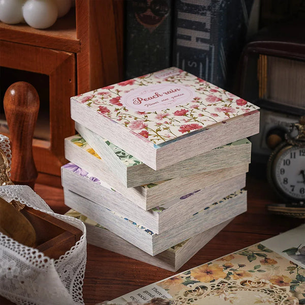 A stack of vintage paper sheets and a wooden stamp are displayed on a dark wooden surface.