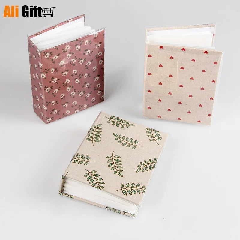 A set of three photo memory albums featuring floral and leaf patterns in pink, beige, and light red tones.