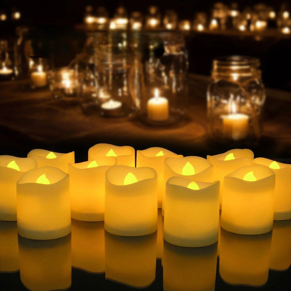 A row of glowing yellow LED tea light candles casting a warm light on a dark surface.