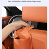 A hand is installing a semi-open design car seat back organizer and headrest hanger in an orange car seat.