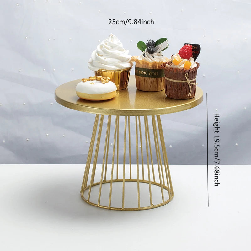 Goldener Metallstand für drei verzierte Cupcakes und einen kleinen Kuchen auf einem runden Sockel.