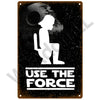 A vintage metal sign featuring a silhouette of a person and a moon against a dark background with the text USE THE FORCE.