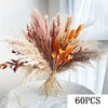 A bouquet of natural dried eucalyptus flowers featuring feathery plumes in shades of beige, brown, and orange.