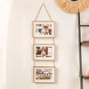 A set of three wooden collage photo frames with twine hanging on a wall.