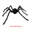 A large black plush spider with eight legs and red eyes, used as a Halloween decoration.