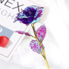 A close-up of a vibrant purple crystal flower with iridescent blue and pink petals on a gold stem.