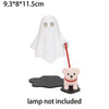 White ghost figurine with a red stick and a small pink dog figure on a black base