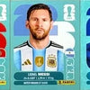 Three football players Cristiano Ronaldo, Lionel Messi, and Kylian Mbappé on Panini 2026 FIFA World Cup sticker boxes.