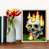 An art print featuring a pixelated skull engulfed in bright orange and yellow flames on a dark background.