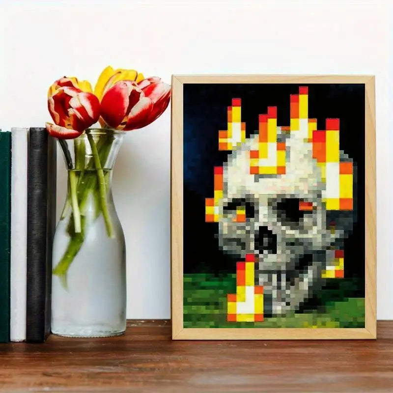 An art print featuring a pixelated skull engulfed in bright orange and yellow flames on a dark background.