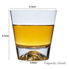 A clear whiskey glass with a heavy base, filled with amber-colored liquid.