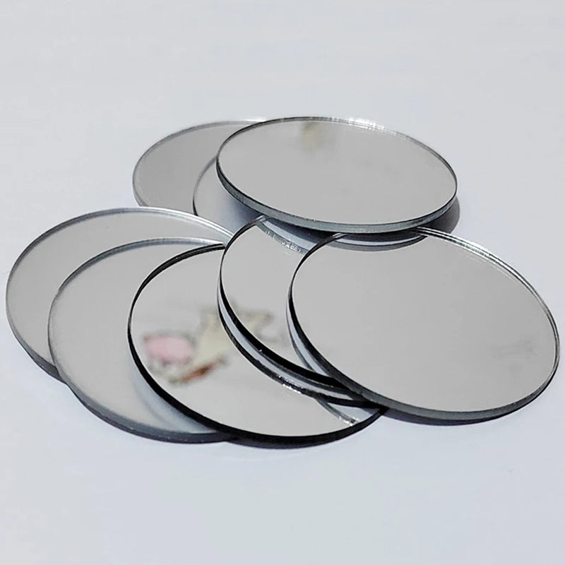 Un juego de diez pegatinas decorativas de espejo acrílico circulares, dispuestas en una superficie blanca.