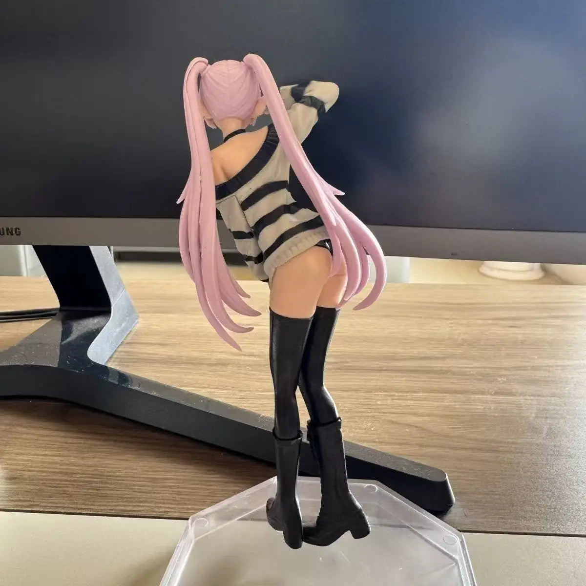 Anime-style girl figurine with long pink hair wearing a striped sweater and black boots.