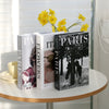 A set of three modern decorative fake books titled Paris Flowers and Paris, featuring yellow flowers in the background.