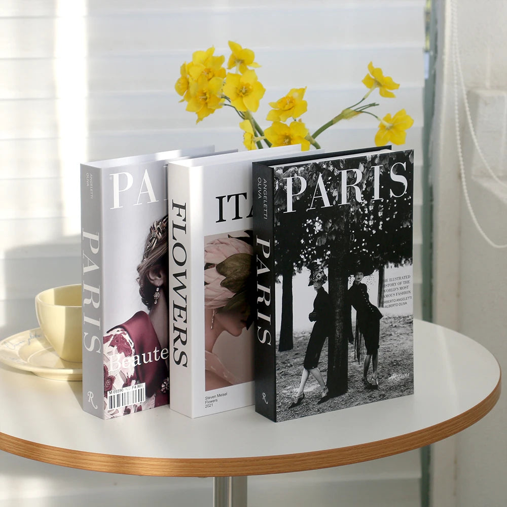 A set of three modern decorative fake books titled Paris Flowers and Paris, featuring yellow flowers in the background.