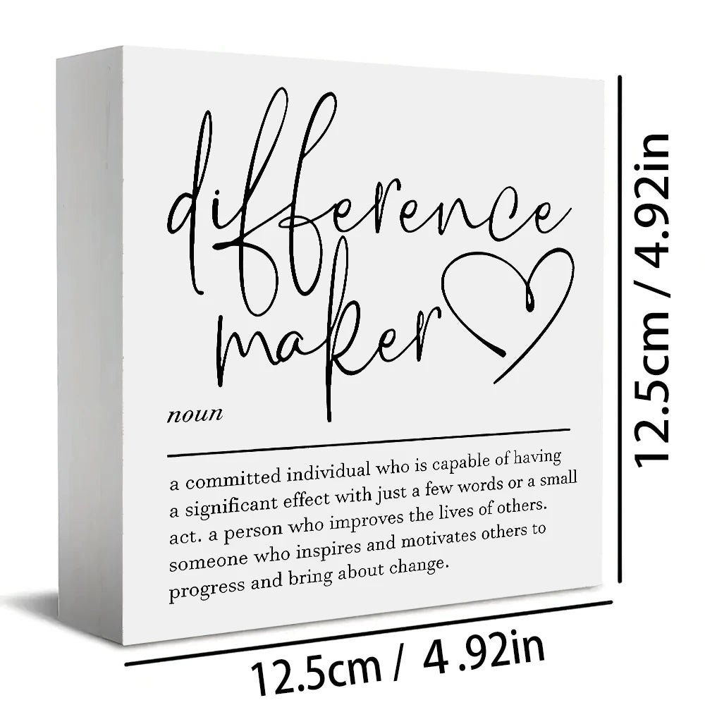 A white wooden sign with black script that reads difference maker.