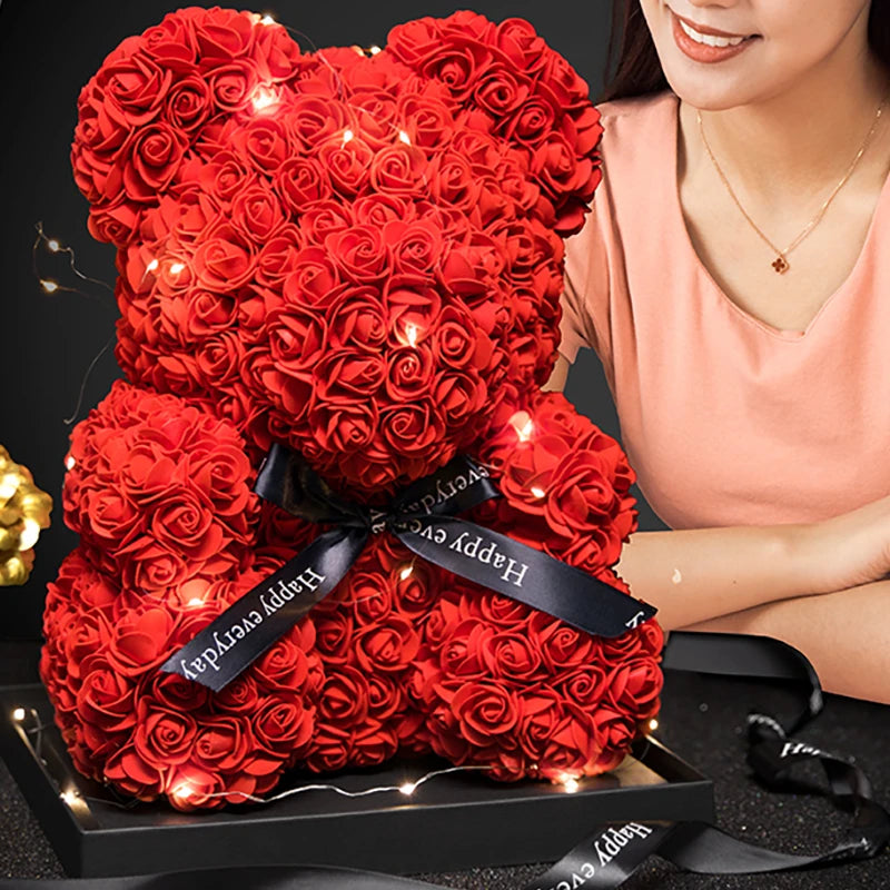 Un ours rose vif en forme de rose, rembourré de tissu et décoré de lumières LED lumineuses.