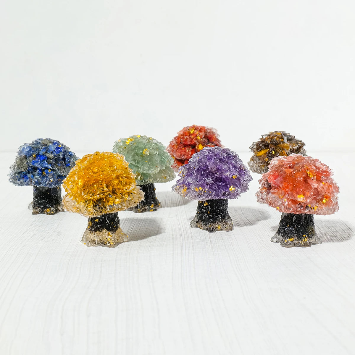 A collection of natural crystal mushroom trees displaying various colors including blue, yellow, green, purple, and orange.