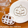 White silicone pumpkin cookie cutter and fondant stamp set on a wooden surface