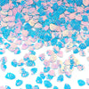 A close-up of iridescent blue and pink sea shell PVC sequins scattered on a white background.