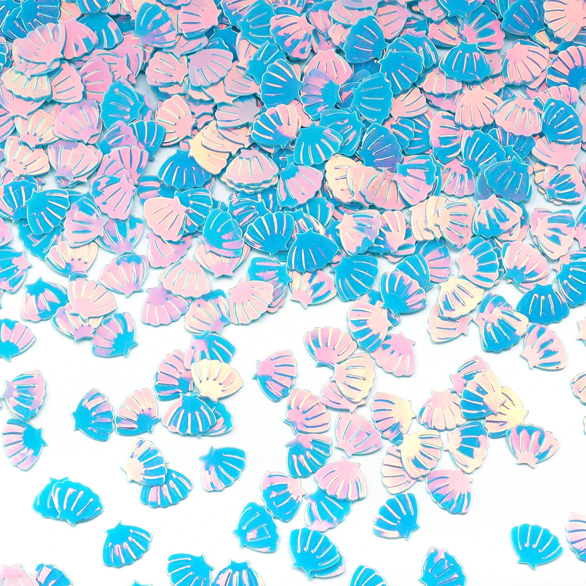 A close-up of iridescent blue and pink sea shell PVC sequins scattered on a white background.
