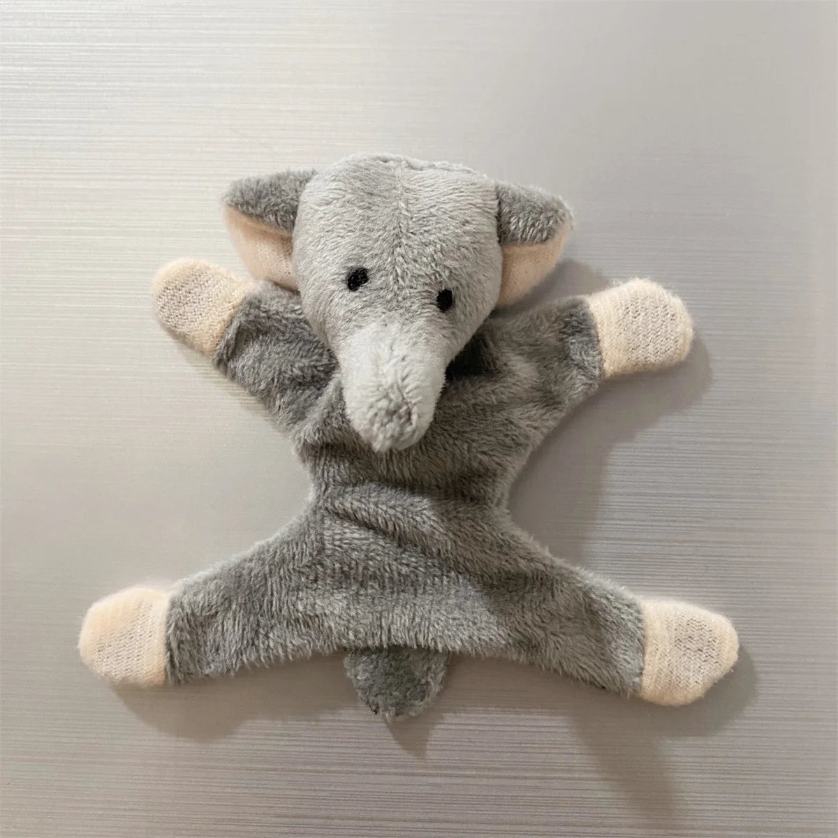 A soft gray elephant plush toy designed as a fridge magnet.
