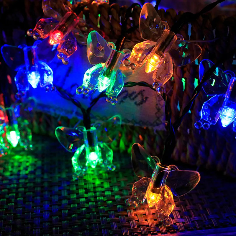 String lights with glowing glass orbs are strung on a wire and displayed against a dark background.