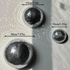 Collection de boules de verre miroirs ronds ou décorations murales présentées sur fond gris clair.