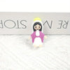 A small resin statue of the Virgin Mary with a white robe, pink garment, and yellow halo, displayed on a white textured surfa