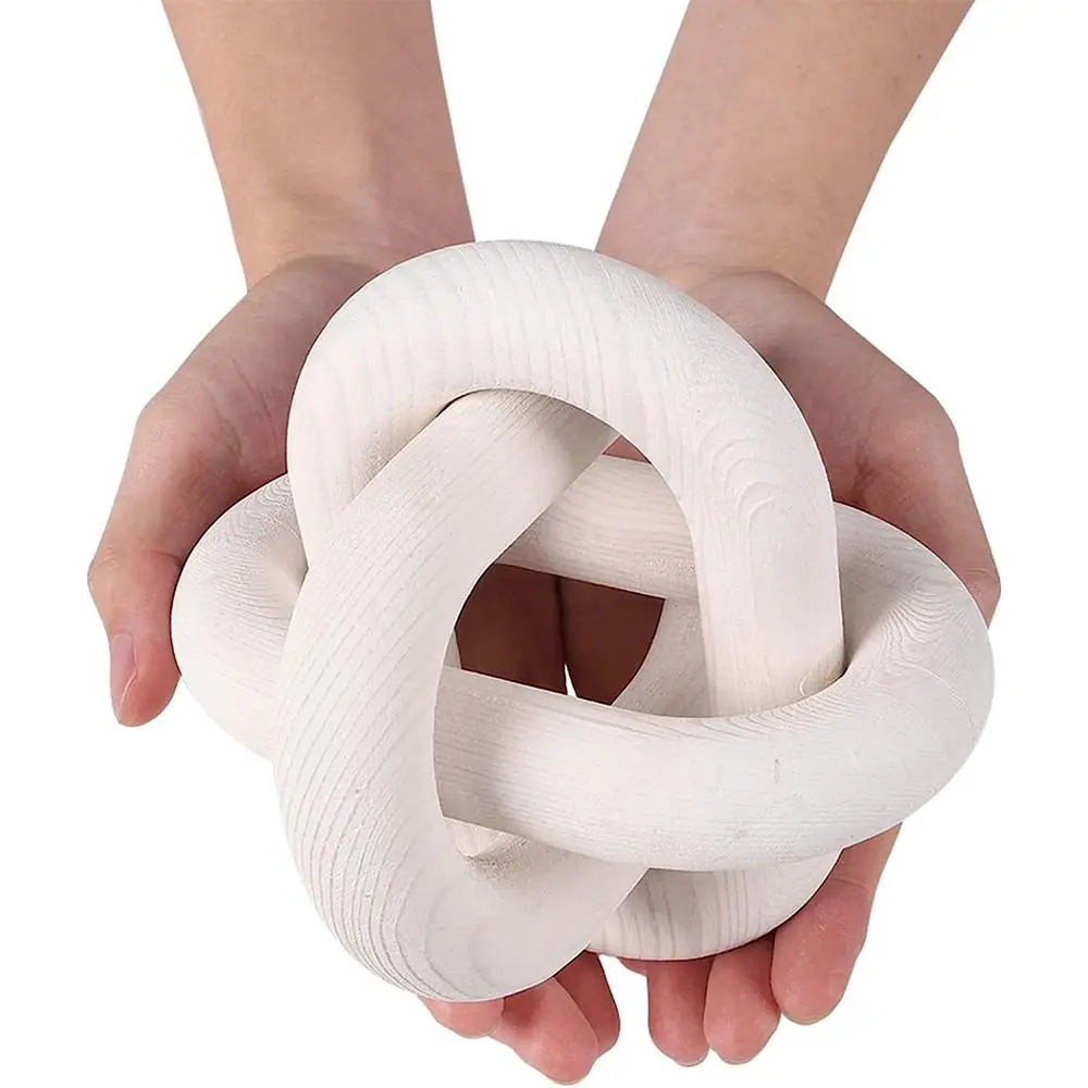 Hand carved white wood knot decor being held in cupped hands