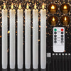 A set of white LED taper candles with a remote control and timer displayed against a dark background.