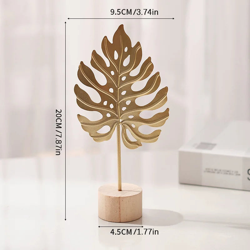 A golden iron ginkgo leaf ornament mounted on a wooden base.