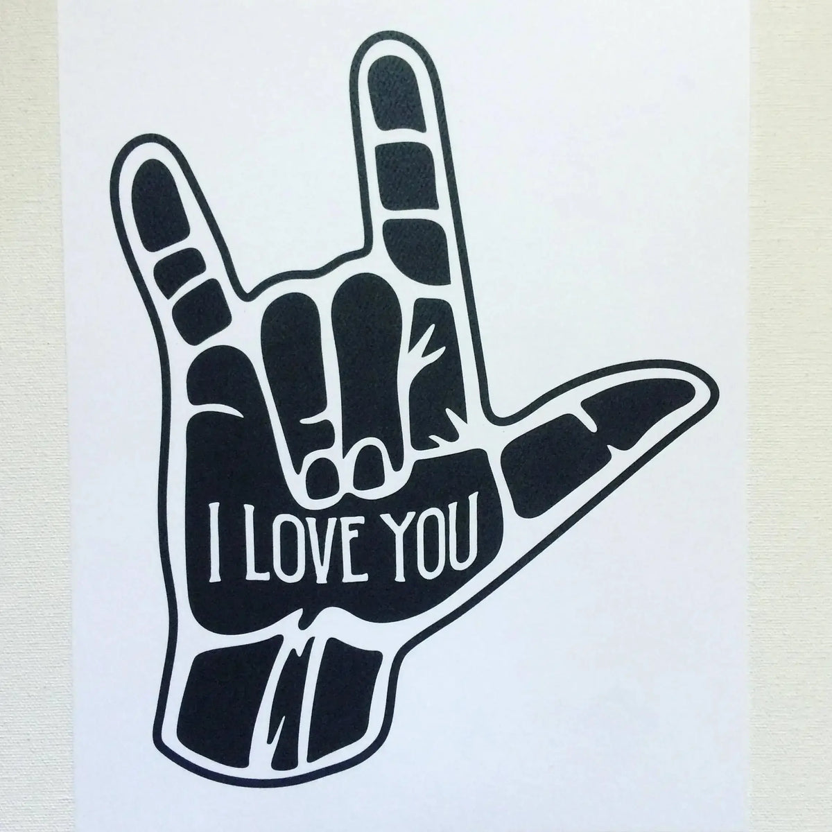Mano silueta negra con la señal 'I LOVE YOU' pintada en la palma