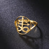 A gold signet ring featuring a Leviathan cross design resting on a dark surface.
