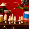 A set of wooden Christmas tree ornaments in various sizes and natural wood tones displayed on a dark wooden surface.