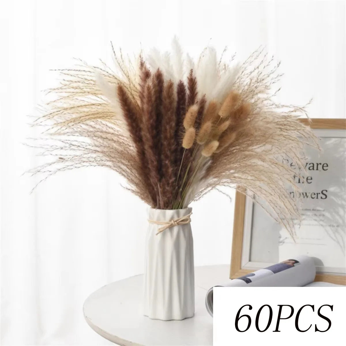 A dried flower bouquet featuring feathery pampas grass in shades of beige, brown, and white arranged in a vase.