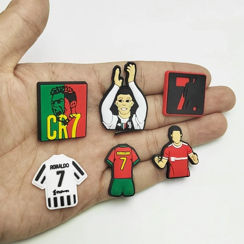 A hand holds several cartoon football shoe charms featuring a number 7 and soccer players.